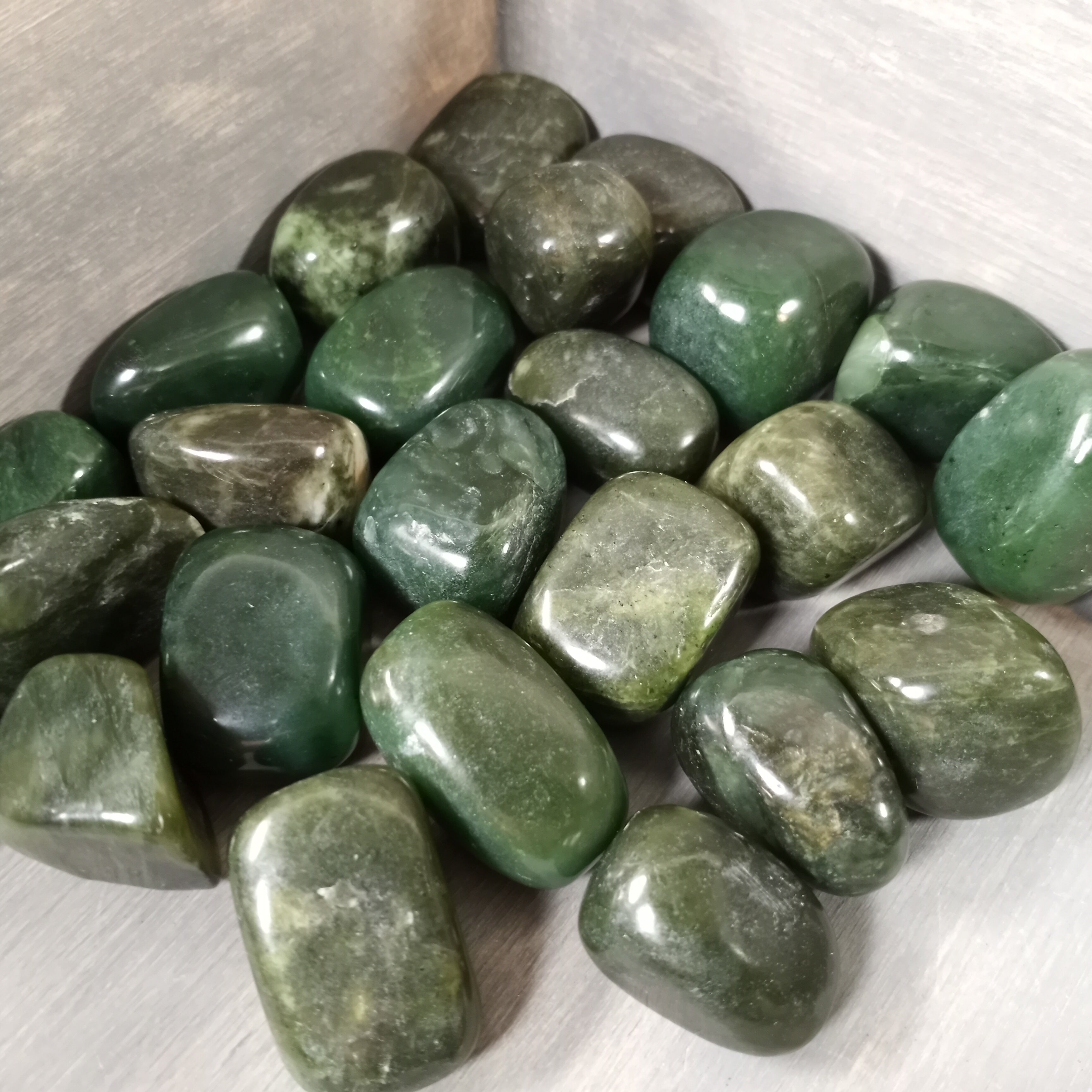 Tumbled green jade stones, perfect for jewelry making or crystal healing, sold by the pound.