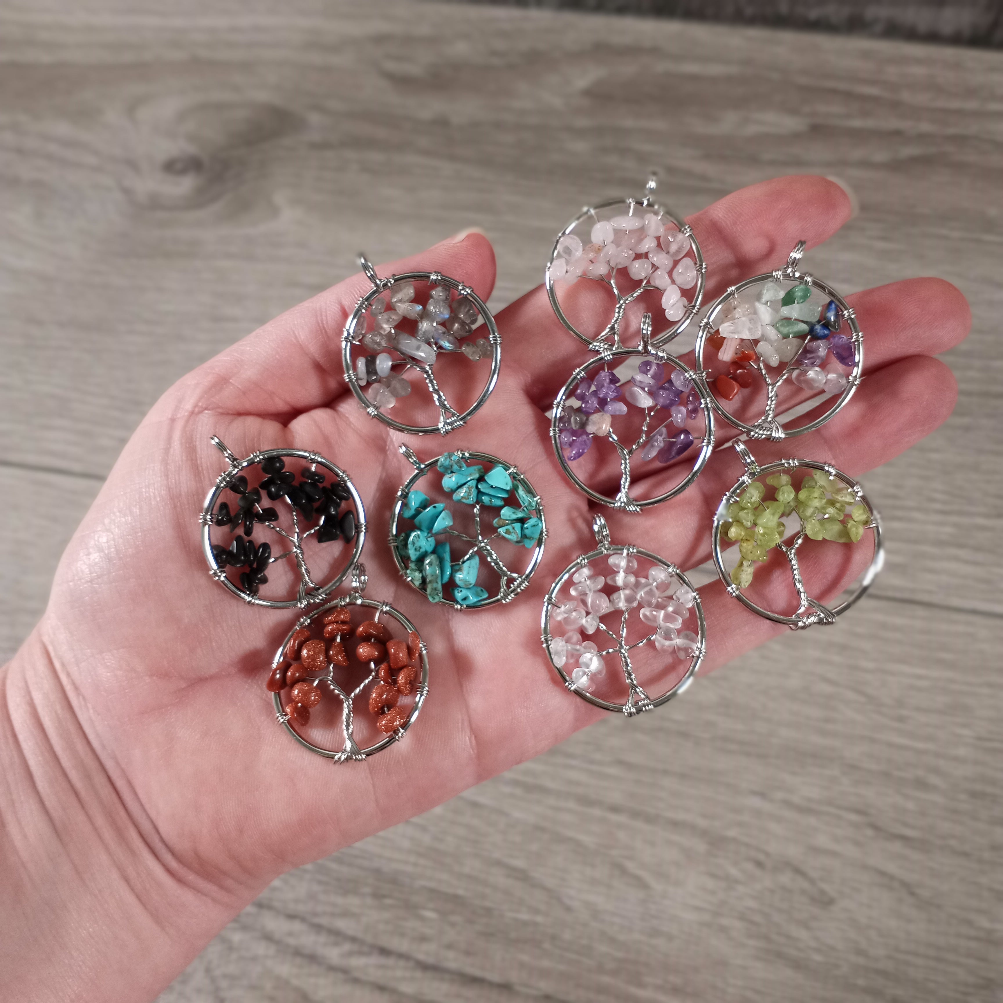 Assorted Tree of Life gemstone pendants displayed for wholesale buyers