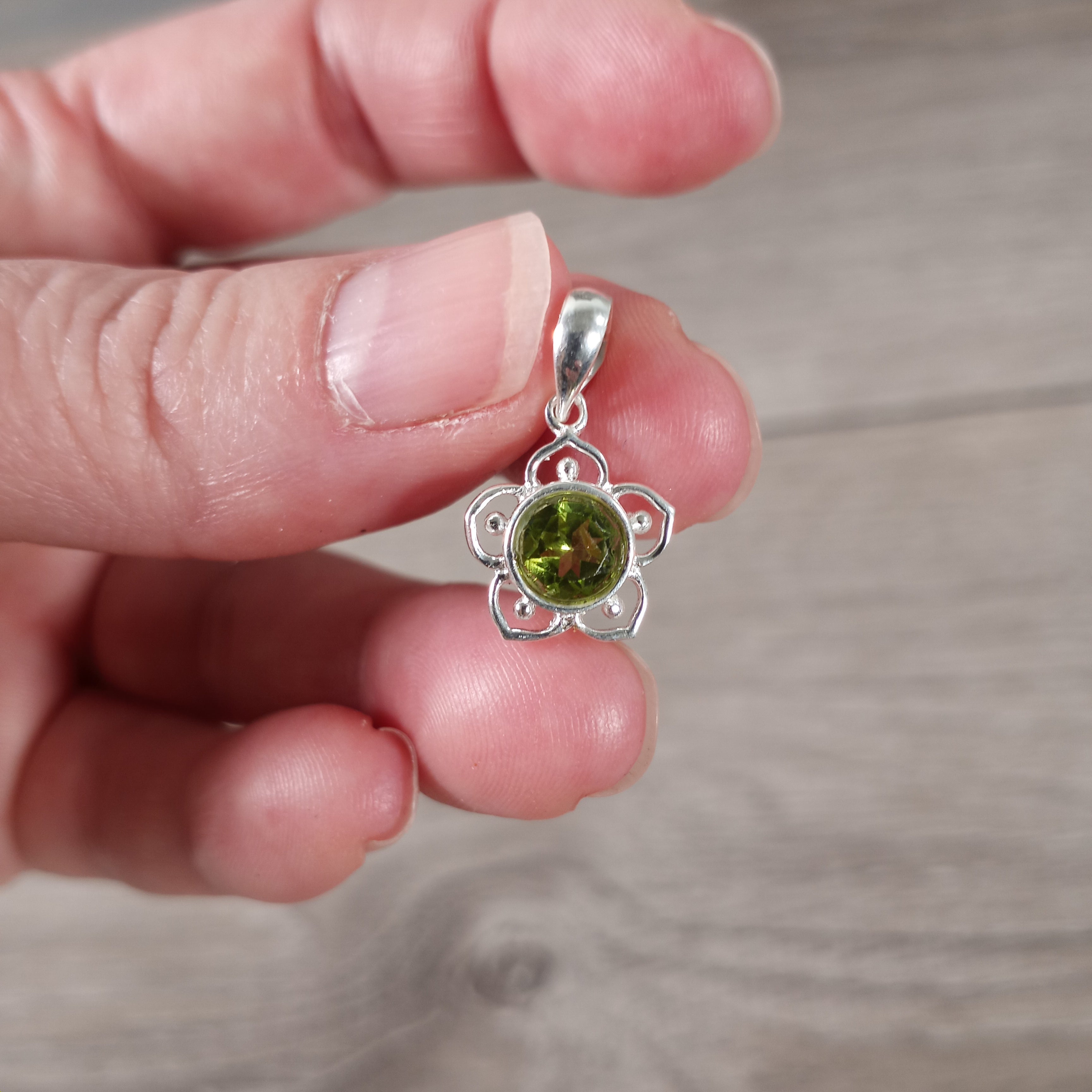peridot Close-up of flower charm pendant with gemstone center in sterling silver