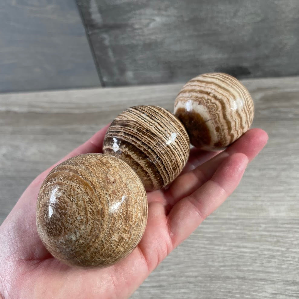 Natural banded Aragonite gemstone sphere for metaphysical retail displays