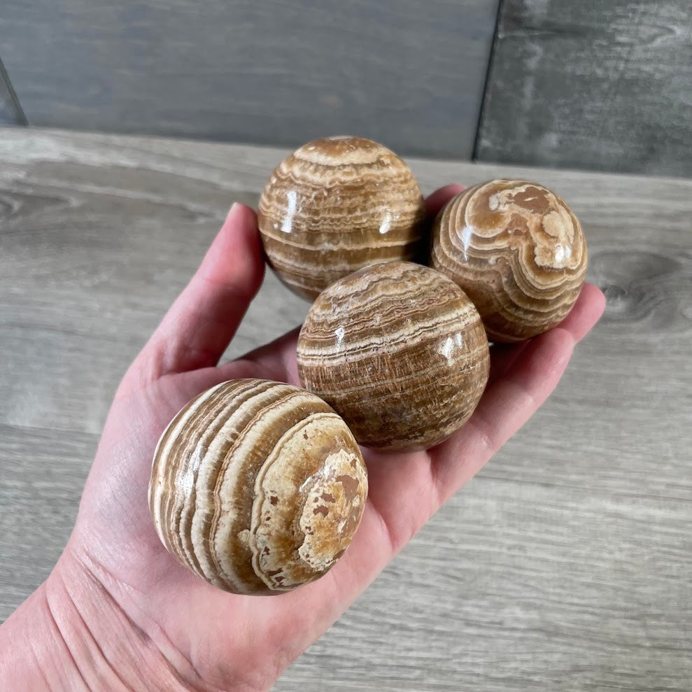 Aragonite earthy banded sphere with natural brown cream and golden mineral patterns