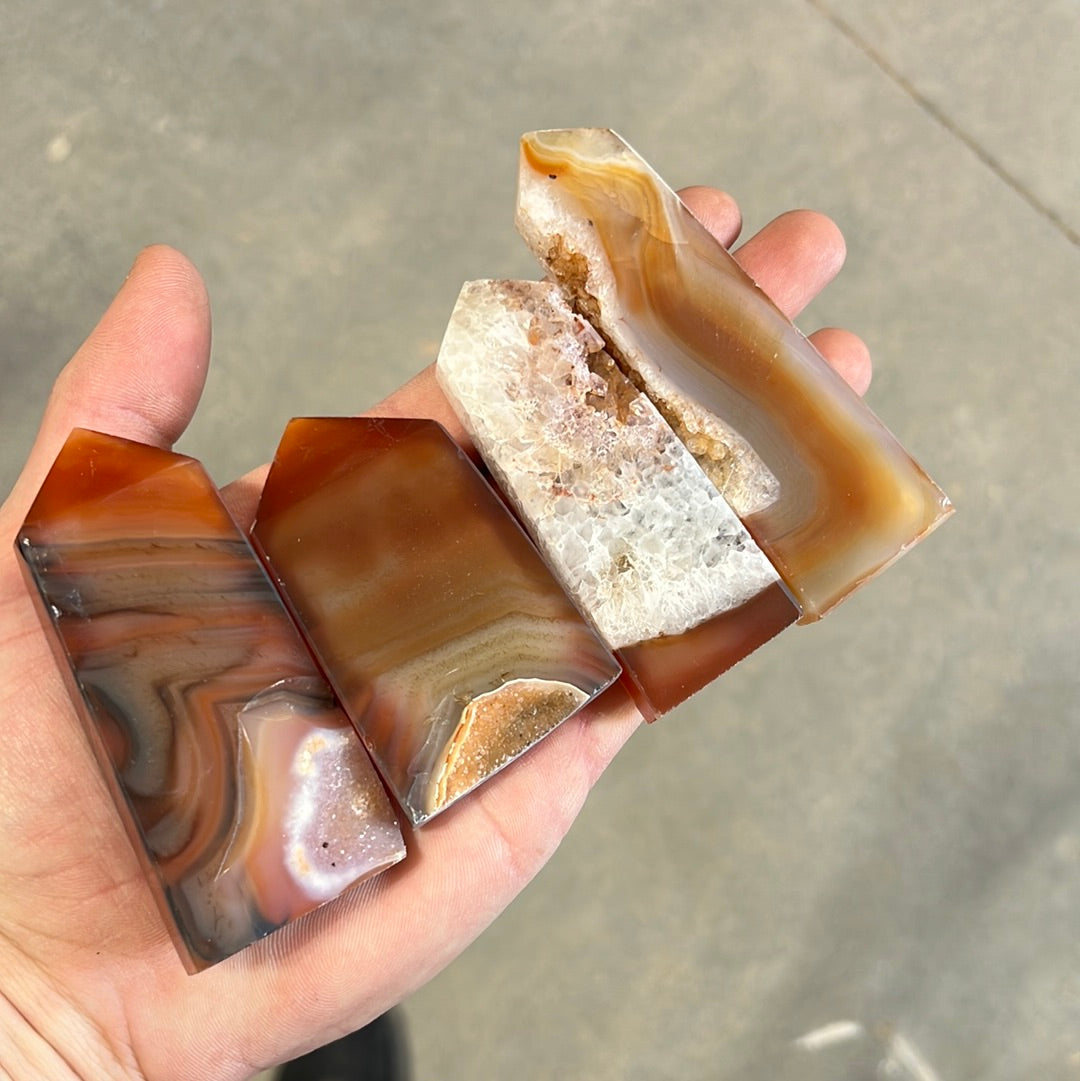 Polished carnelian obelisk with druzy inclusions