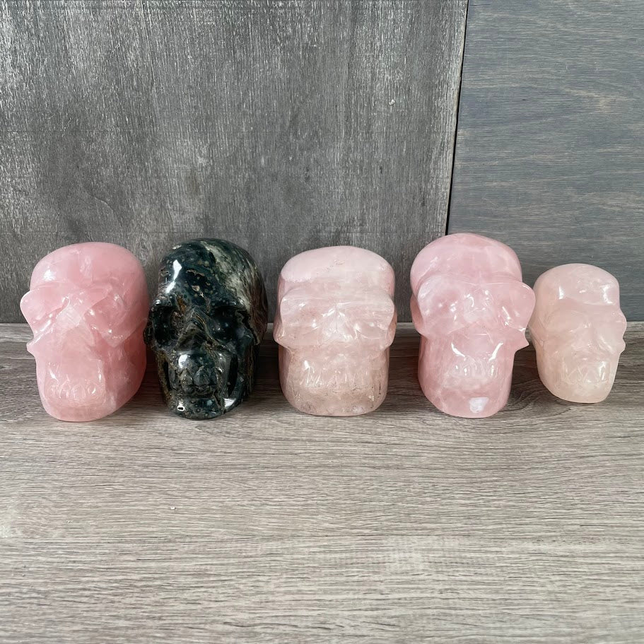 Lot of four rose quartz skulls and one Kambaba jasper skull, for metaphysical shops