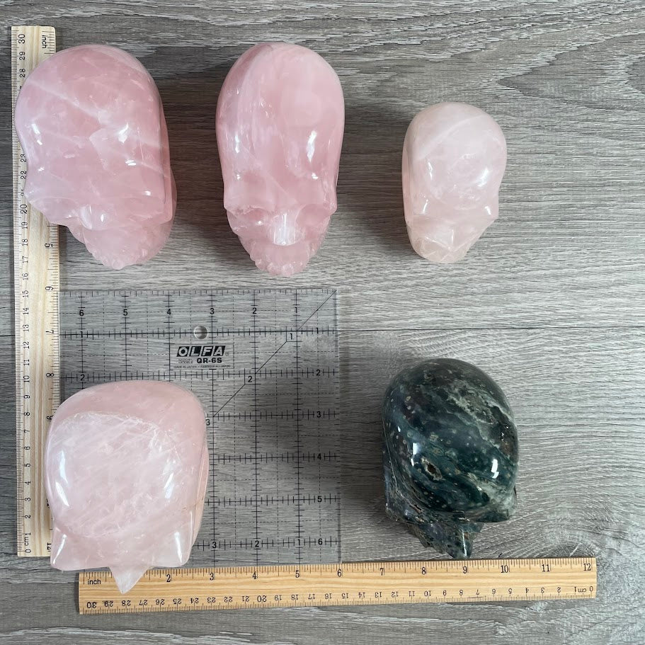 Lot of 5 crystal skulls; four rose quartz and one Kabamba jasper. for new age stores