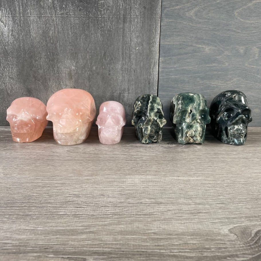 Bulk Lot of three rose quartz and three Kambaba jasper skulls; facing-forward.