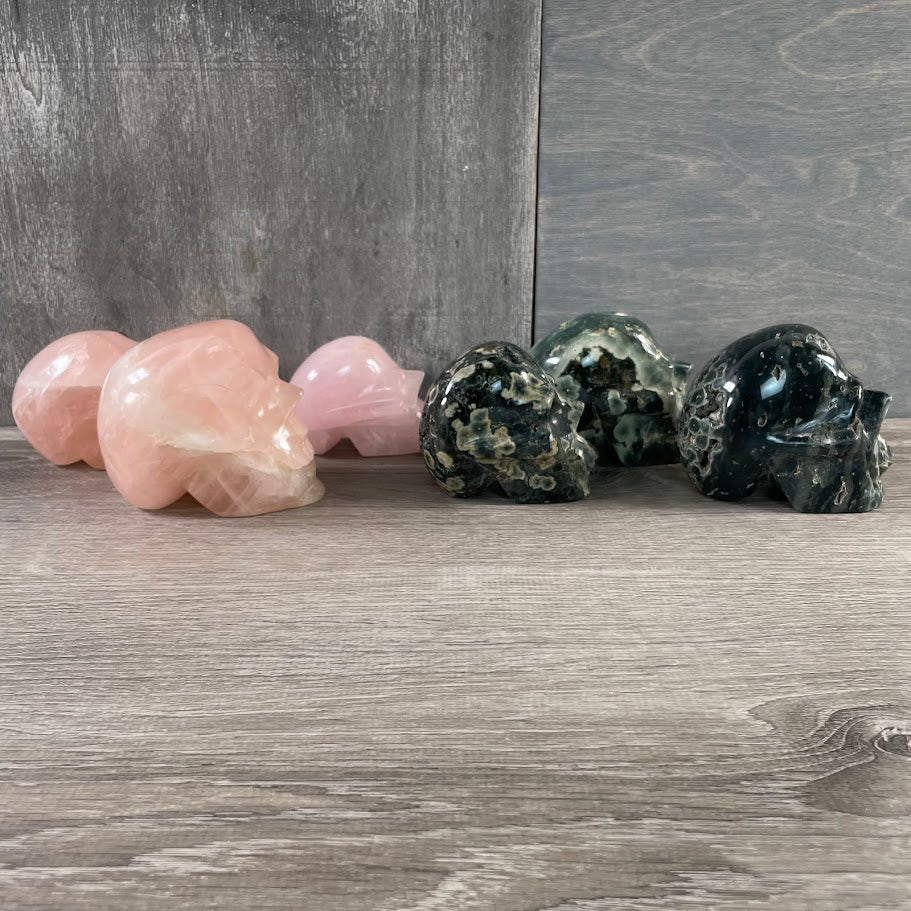 Wholesale Lot of three rose quartz and three Kambaba jasper skulls; facing-side.