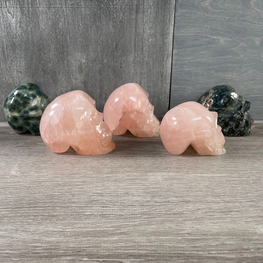 Lot of three rose quartz and two Kambaba jasper skulls; facing side.