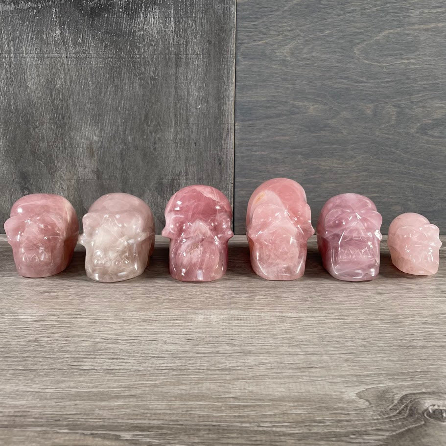 Lot of six rose quartz skulls, facing forwards.