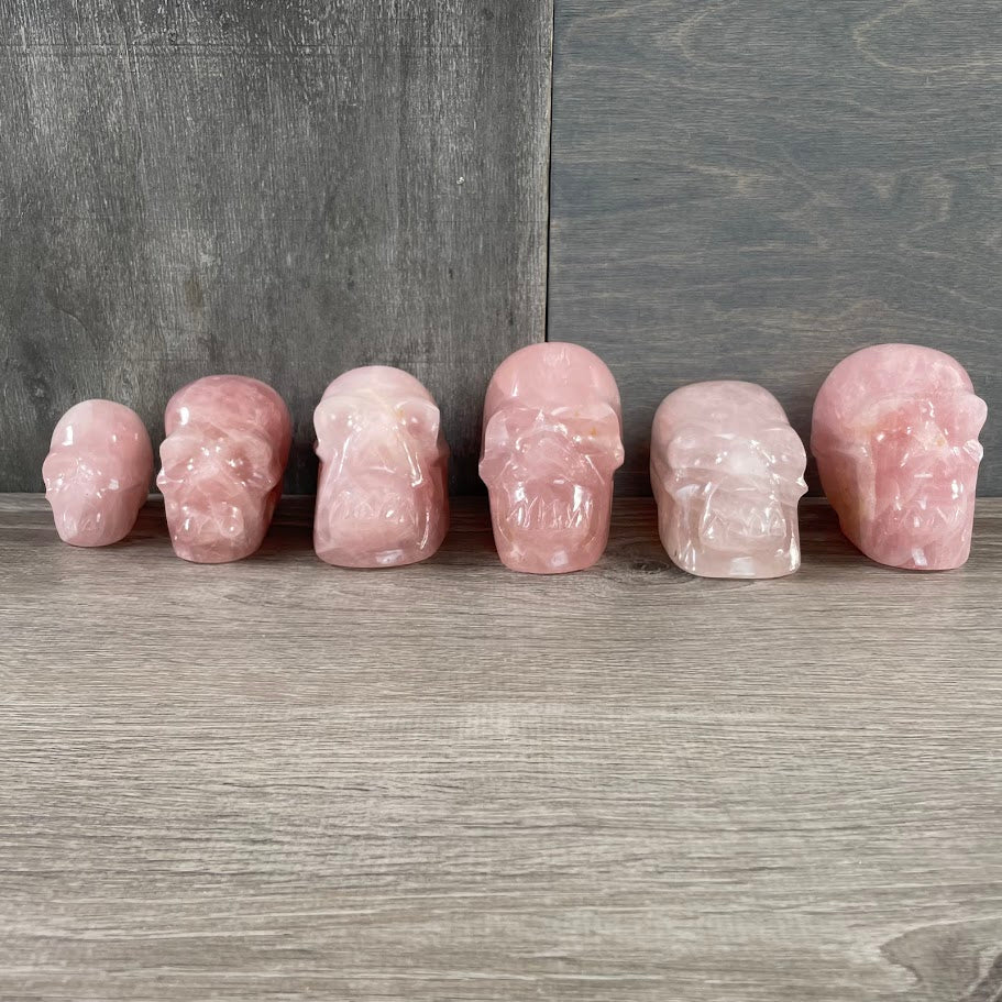 Lot of six rose quartz skulls, facing forwards.
