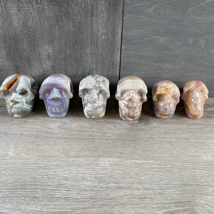 Lot of three quartz and three agate skulls; facing forwards.