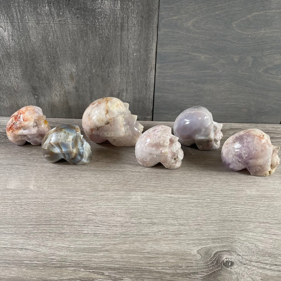 Lot of four quartz and three agate skulls; facing sideways.