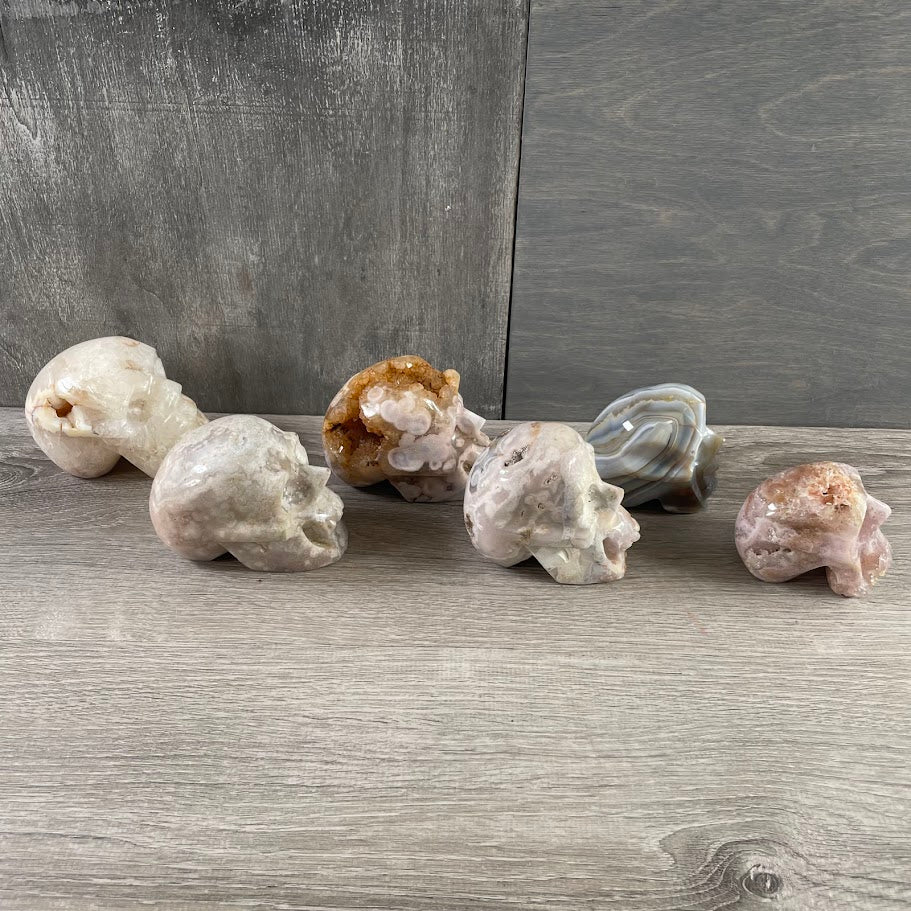 Lot of five quartz skulls and one agate skull; facing sideways.
