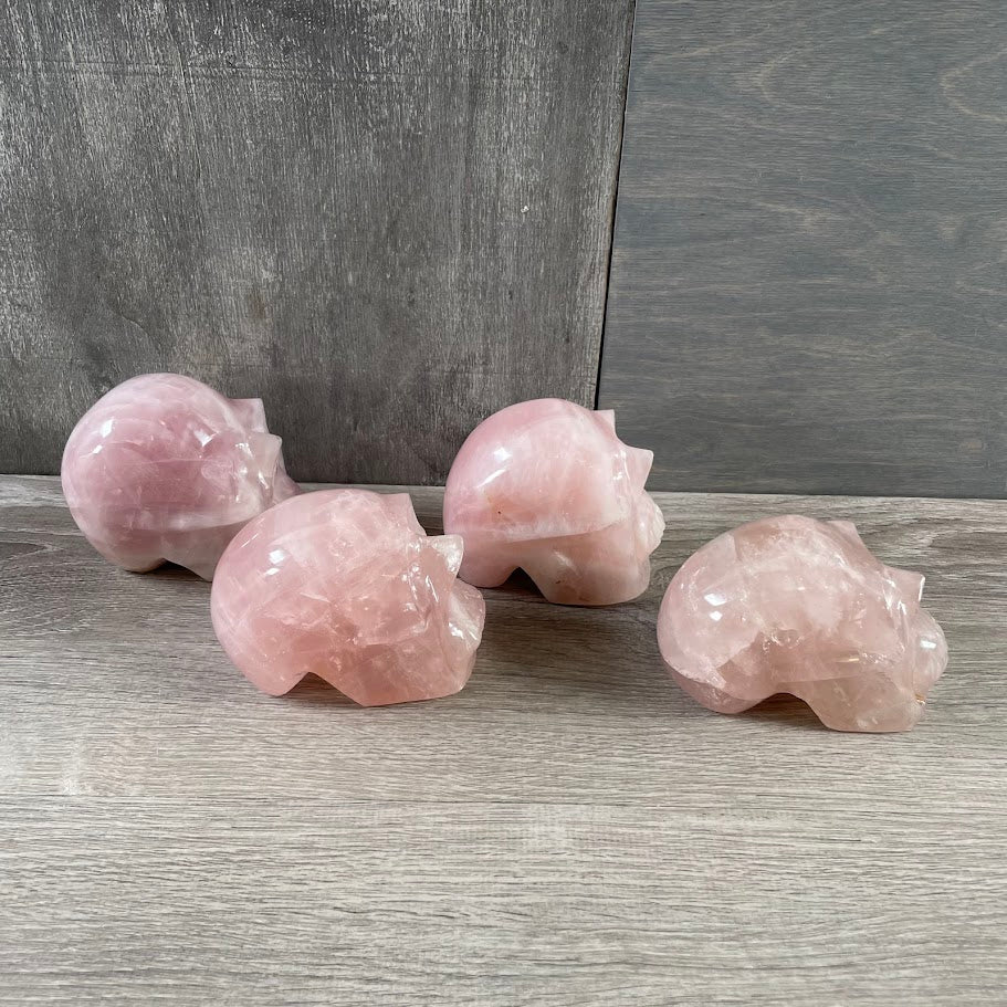 Lot of four rose quartz skulls; facing sideways.
