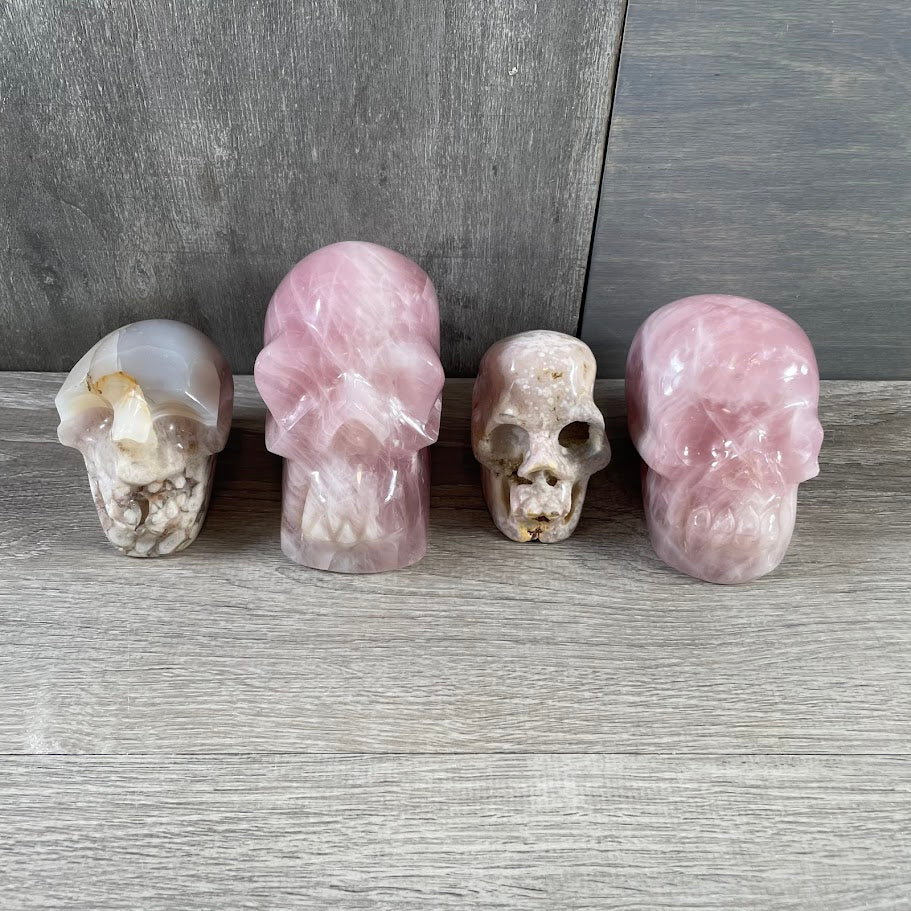 Lot of two rose quartz and two quartz skulls; facing forwards.