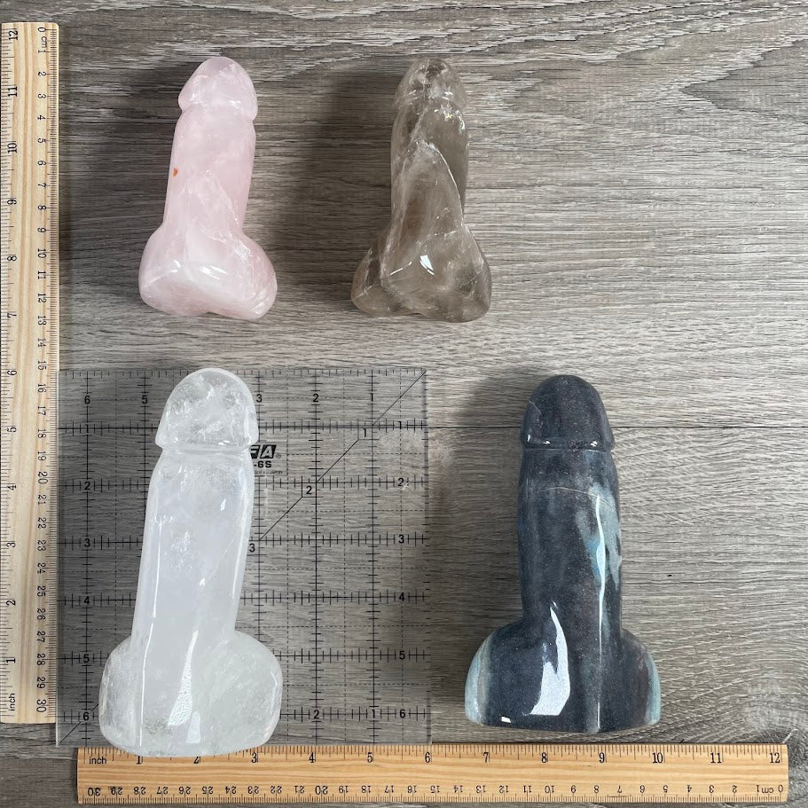 Four Gemstone Penis Figurines: 1 quartz, 1 smoky quartz, 1 trollite and 1 rose quartz, with rulers and grid for size reference.