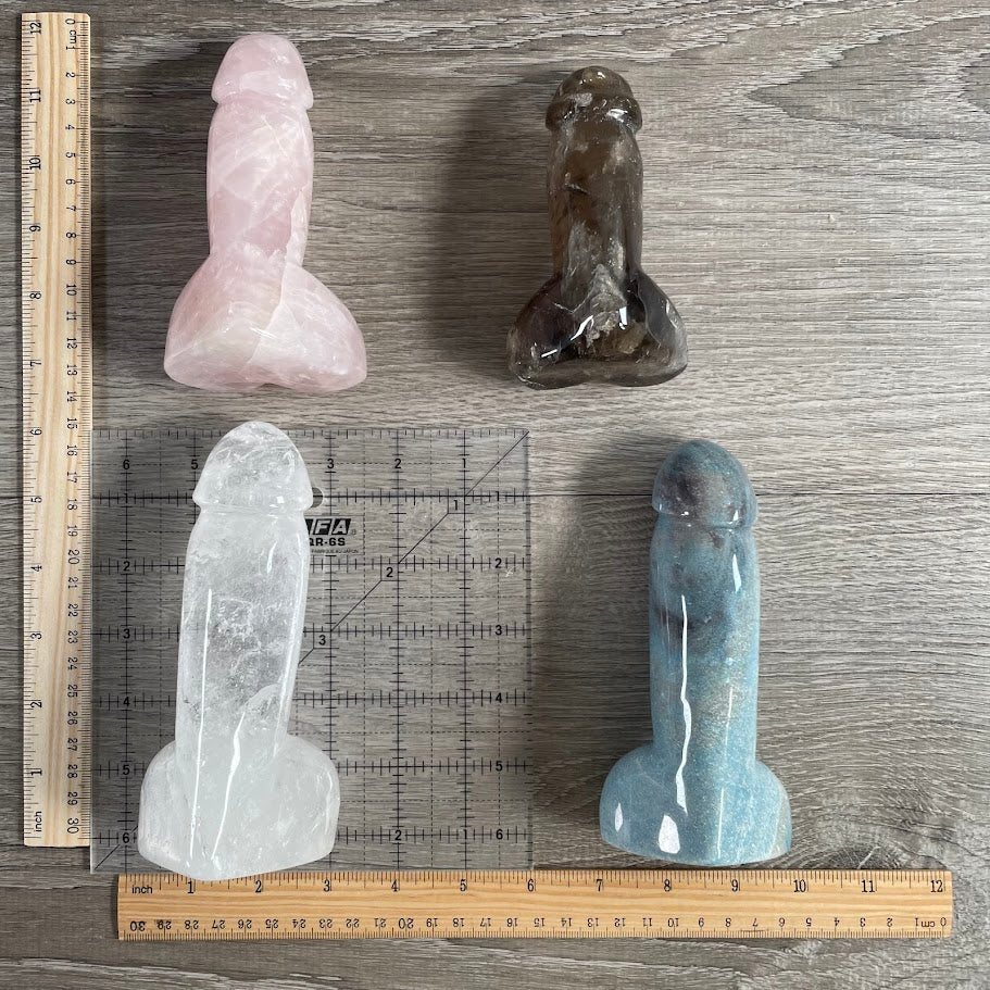 Four Gemstone Penis Figurines: 1 quartz, 1 smoky quartz, 1 trollite and 1 rose quartz, with rulers and grid for size reference.