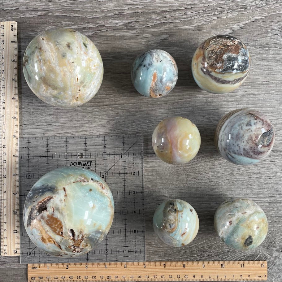 Lot of eight amazonite spheres with grid and rulers with size reference.