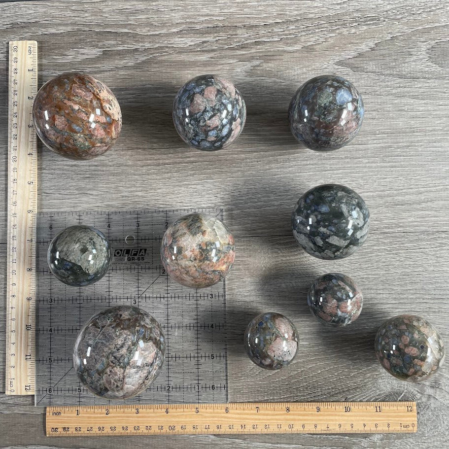 Lot of 10 que sera spheres with grid and rulers for size reference.