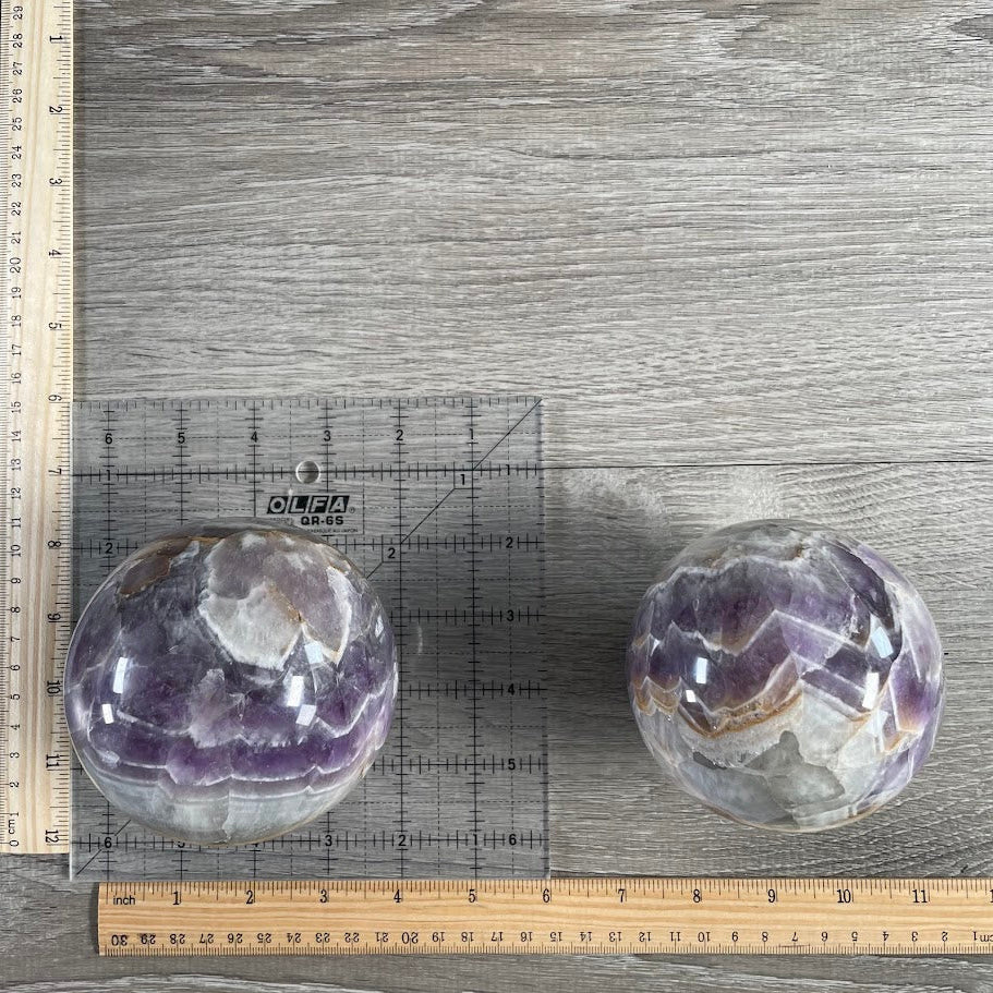 Lot of two amethyst spheres with grid and rulers for size reference.