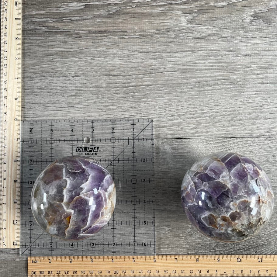 Lot of two amethyst spheres with grid and rulers for size reference.