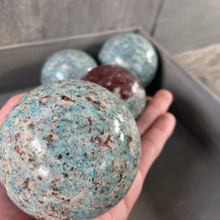 Amazonite with biotite spheres in bulk for metaphysical shops.