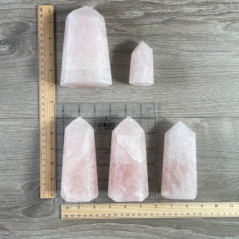 Soft pink rose quartz obelisks standing upright in bulk lot