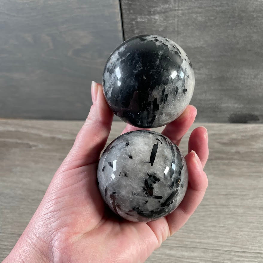 Tourmalinated quartz crystal ball with natural black and white stone patterns