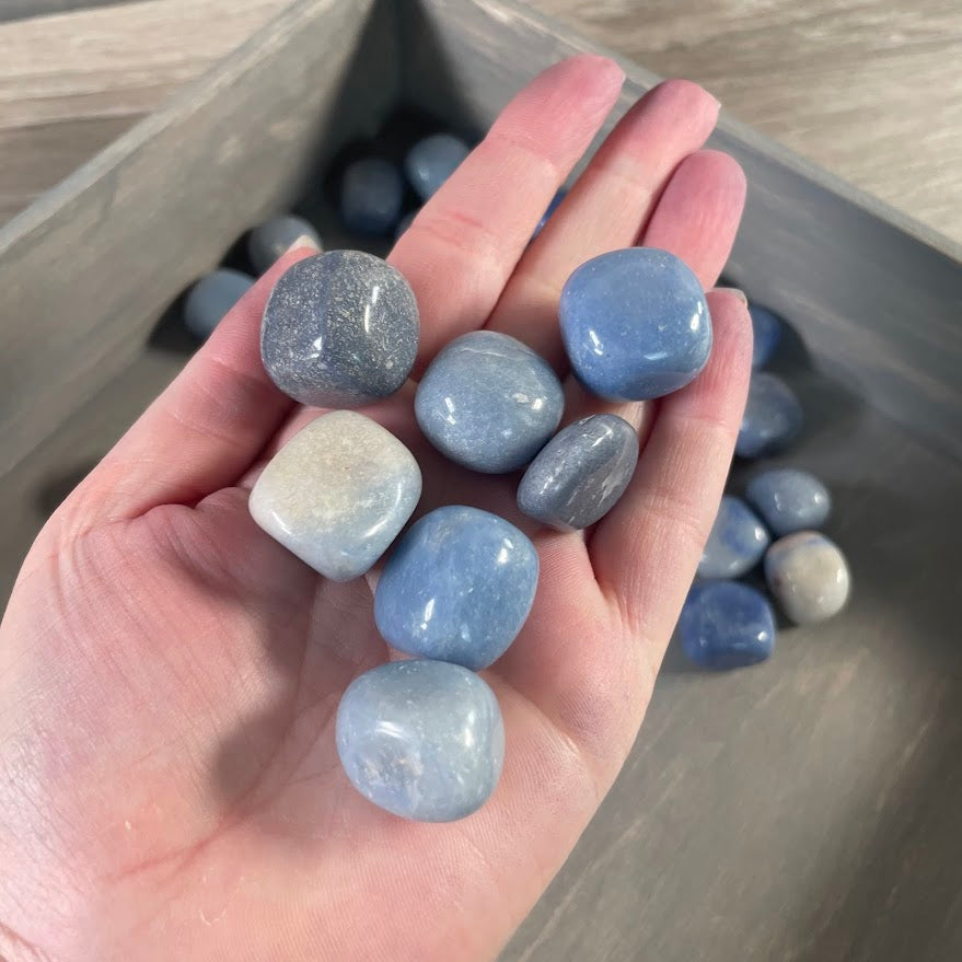 Blue quartz tumbled crystals and polished stones in a bulk gemstone lot for resale and collections