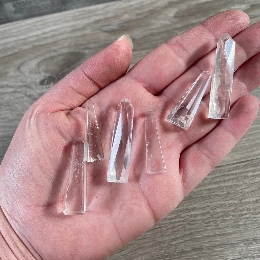 Brazilian clear quartz handmade gemstone obelisk shaped into a polished crystal tower.