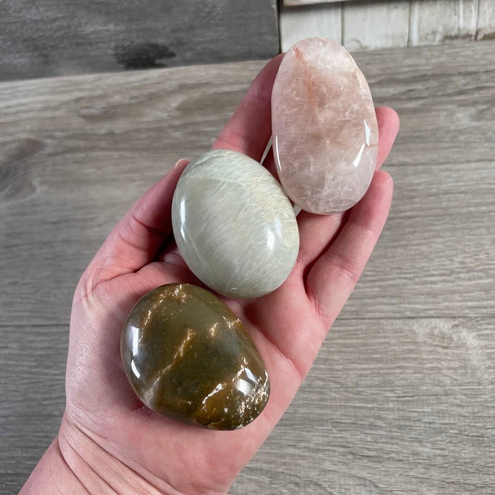 Wholesale gemstone palm stone collection featuring gemstones and natural mineral patterns
