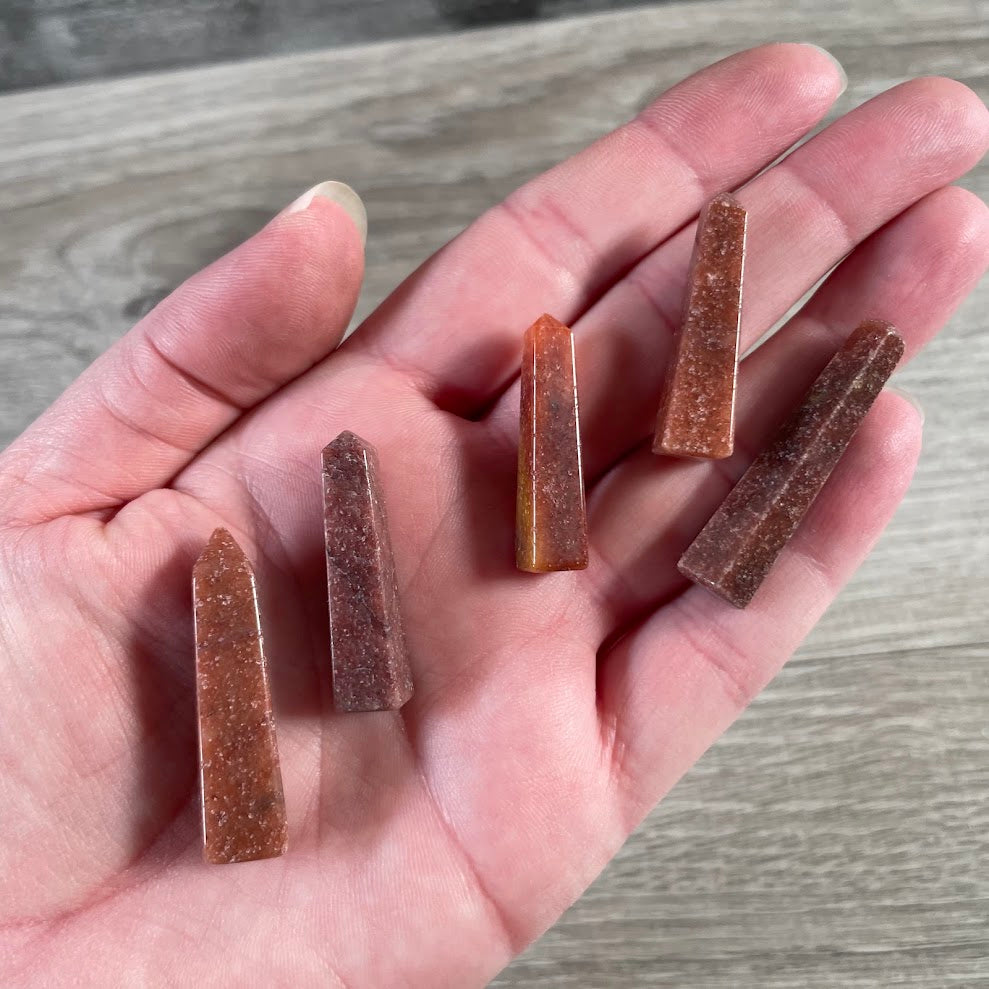 Handmade red aventurine natural stone obelisk from Brazil with pointed crystal tower shape.