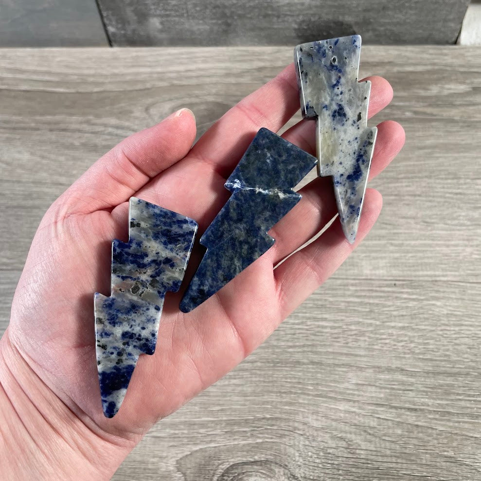 Natural gemstone sodalite carvings shaped like lightning bolts with polished surfaces