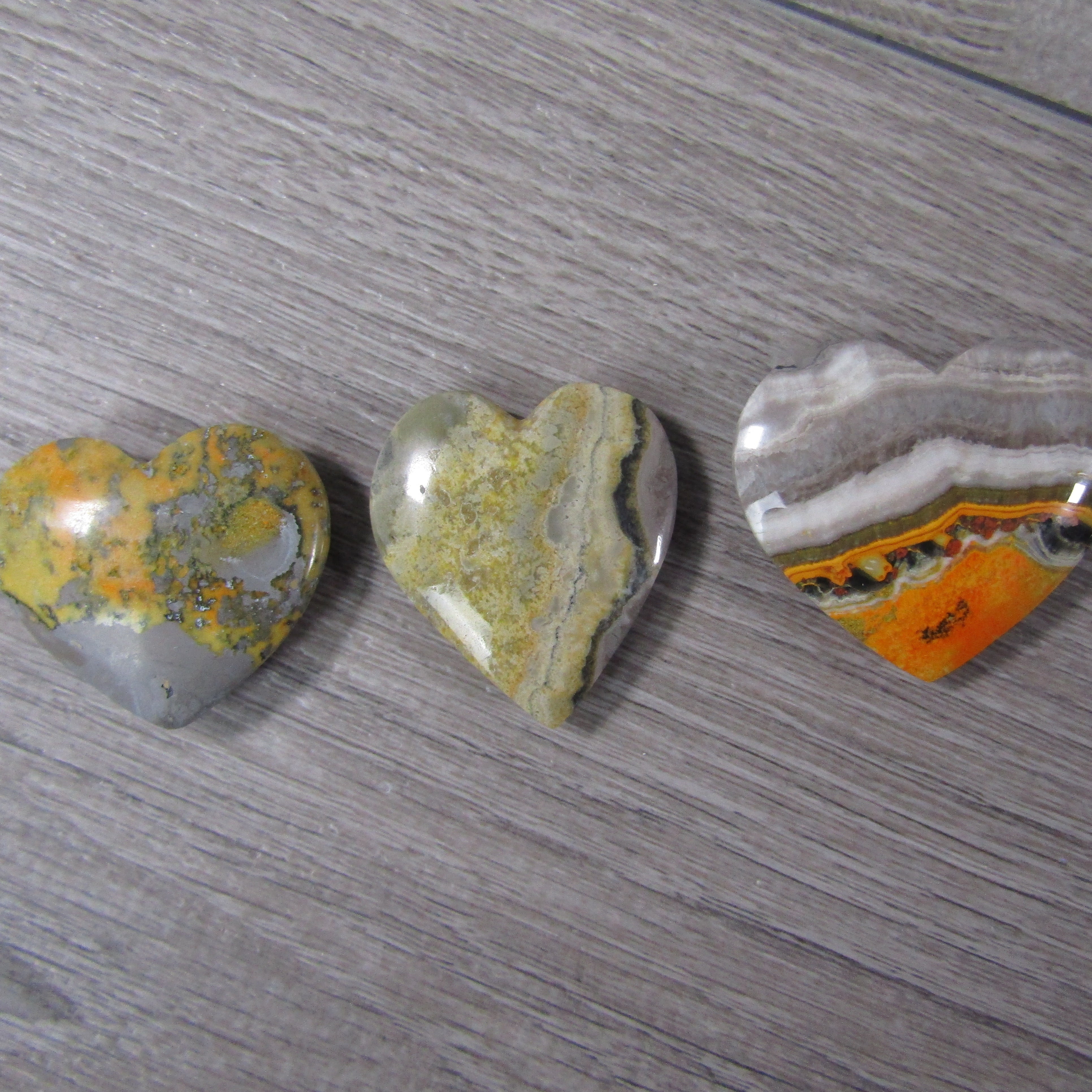 Close-up of Bumble Bee Jasper heart with vibrant yellow and orange patterns