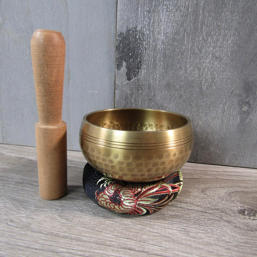 Small singing bowl with wood striker and pillow cushion for metaphysical shops