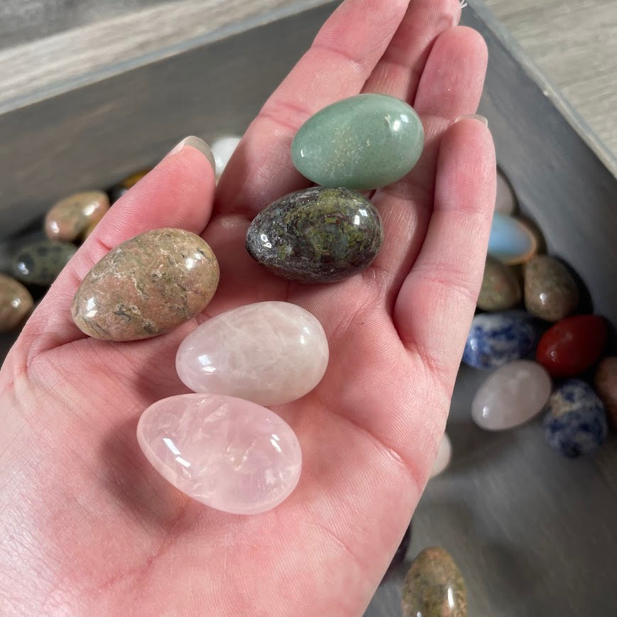 Collection of assorted polished crystal eggs in mixed gemstones