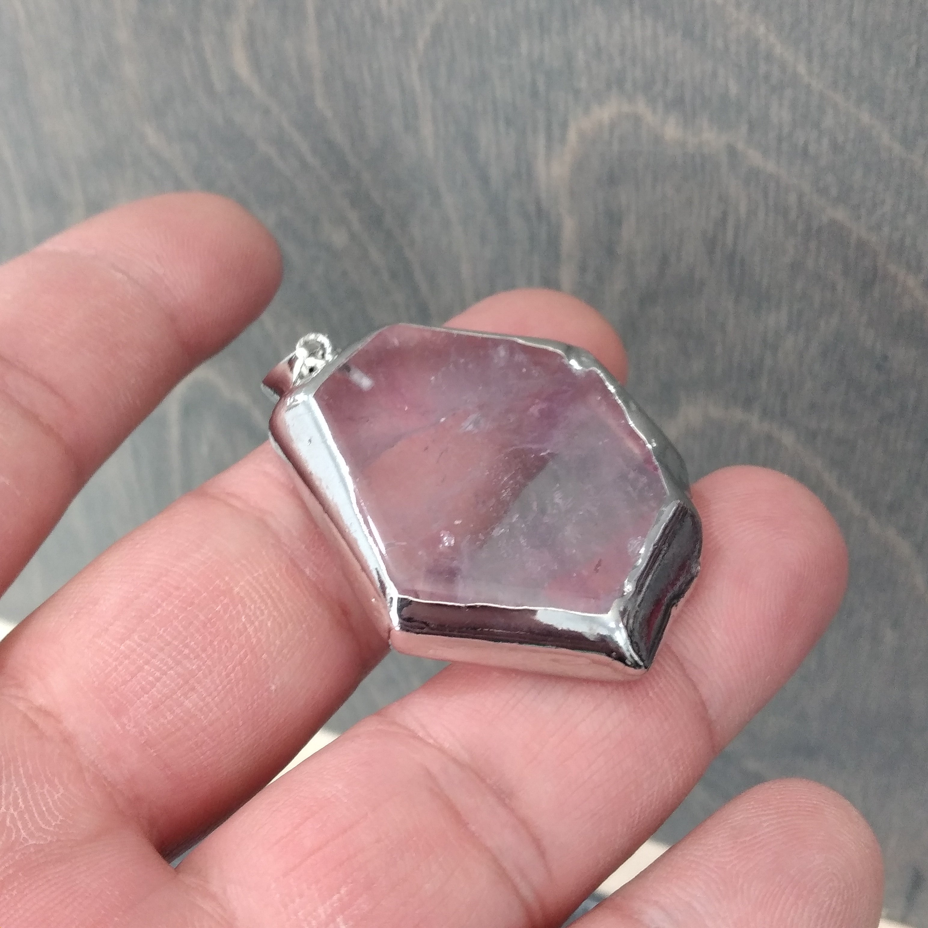 amethyst slab pendant in a hand 