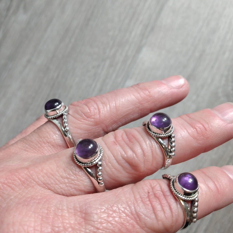 Sterling Silver Ring with a medium size band and a twisted setting and a round amethyst center stone