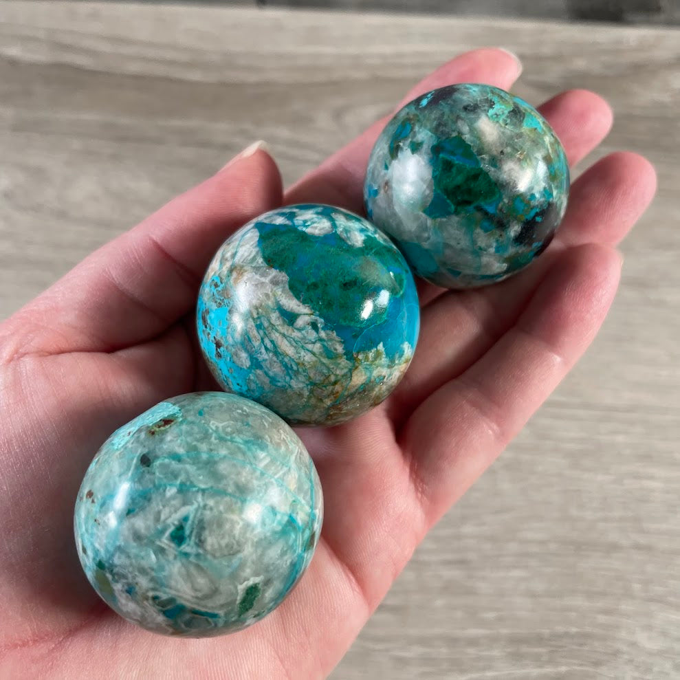 Polished chrysocolla crystal sphere for Reiki meditation and metaphysical retail