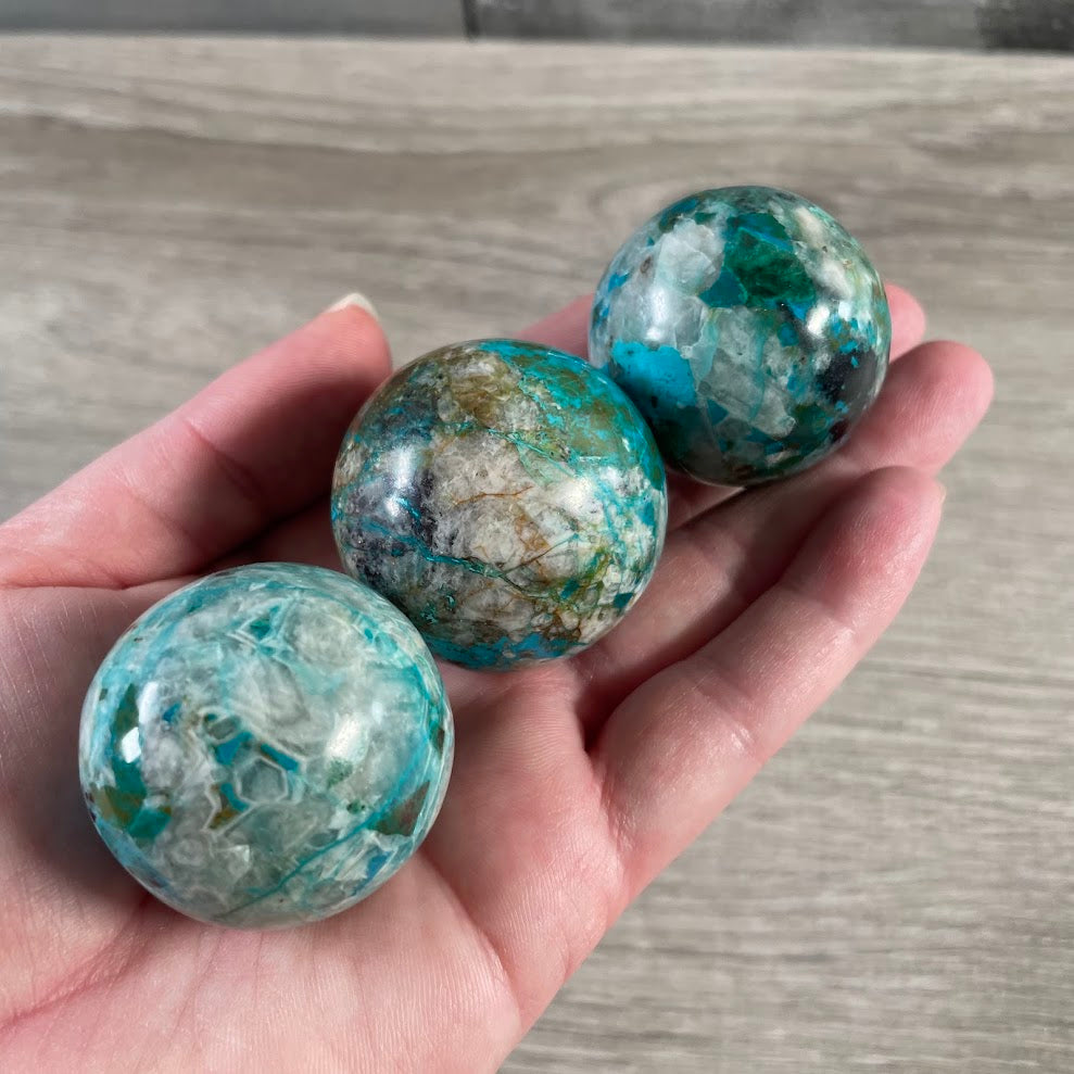 Natural chrysocolla gemstone sphere with teal green and earthy matrix patterns