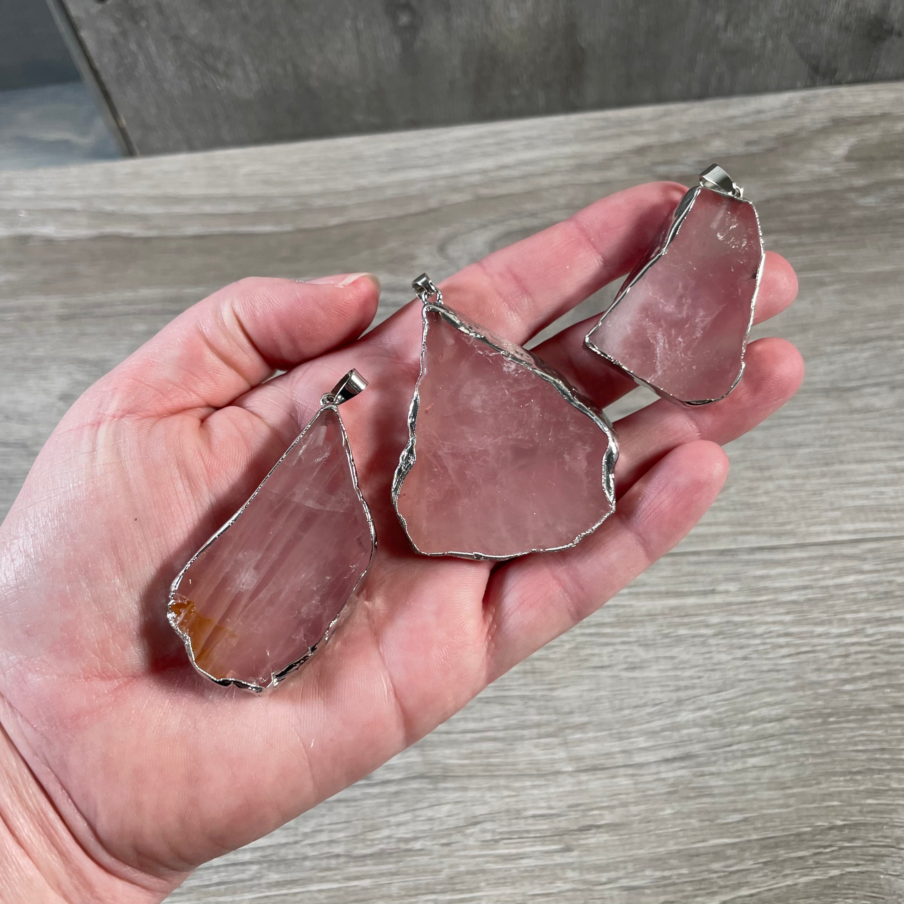 Unique rose quartz slice pendant with silver-toned electroplated edge, ideal for resale.