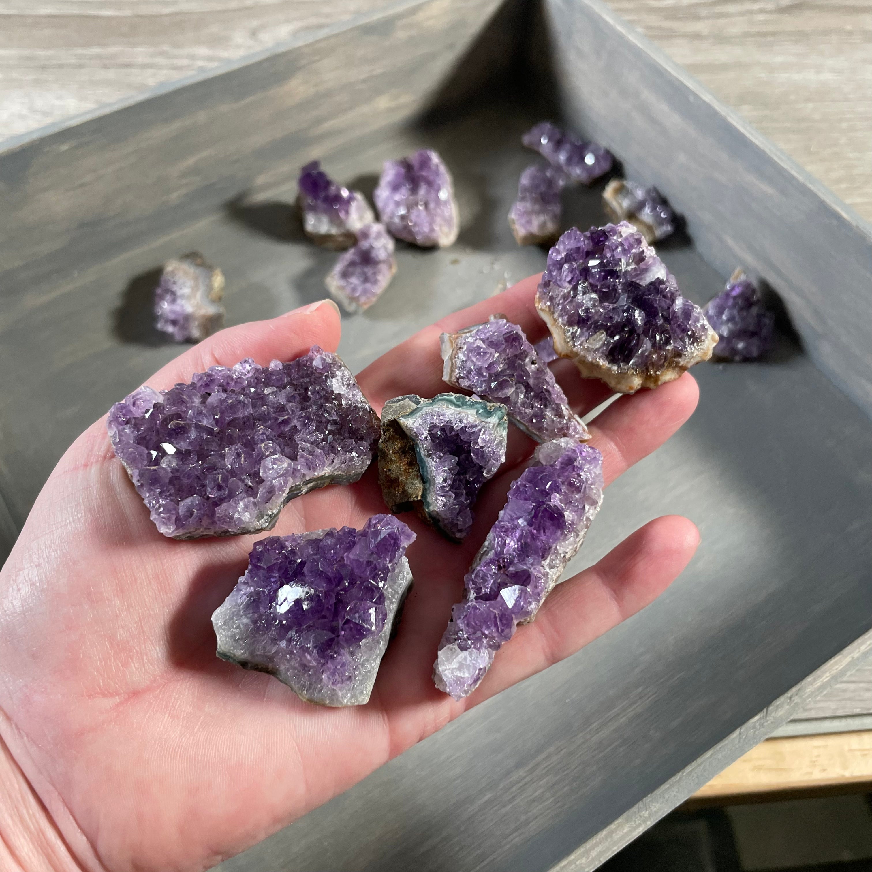 Raw Brazilian amethyst clusters in vibrant purple hues, displayed in a 1-pound lot.