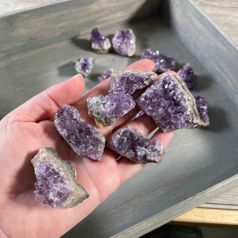 Hand holding a raw amethyst cluster from a premium Brazilian bulk lot.