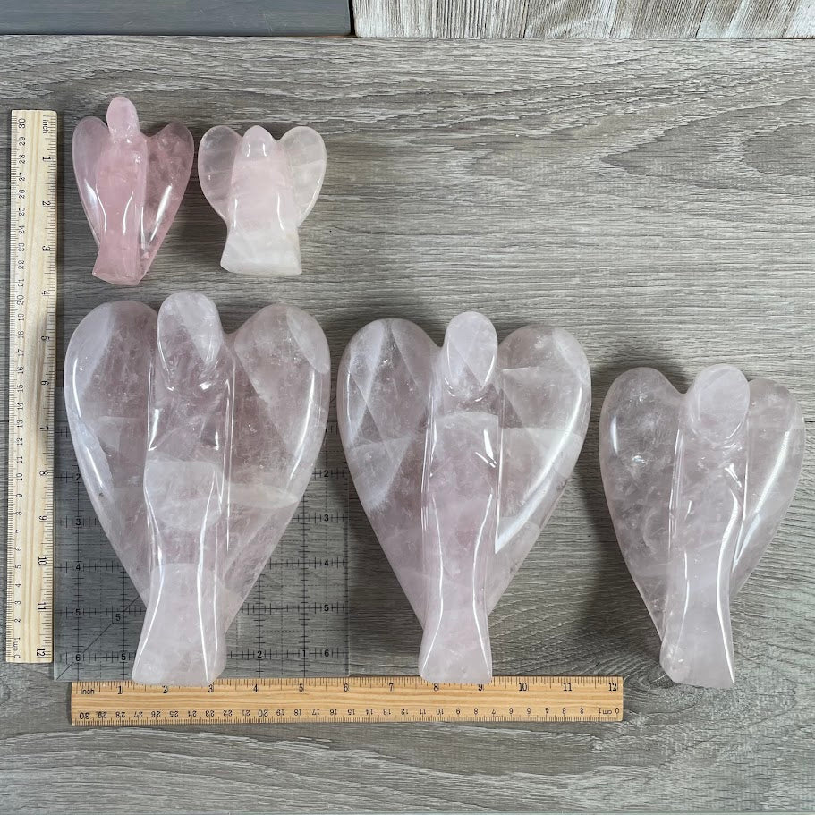 Lot of 5 rose quartz angels (3 large) , next to size reference. 