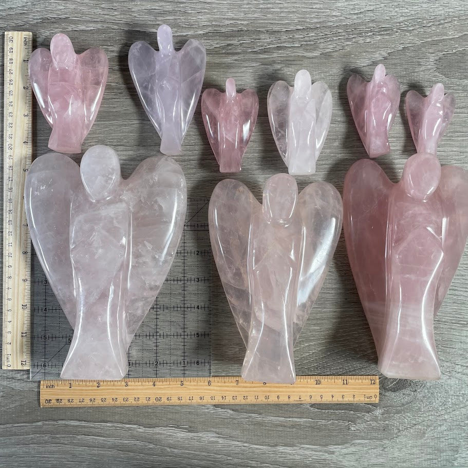 Lot of 9 rose quartz angels (3 large), next to size reference. 