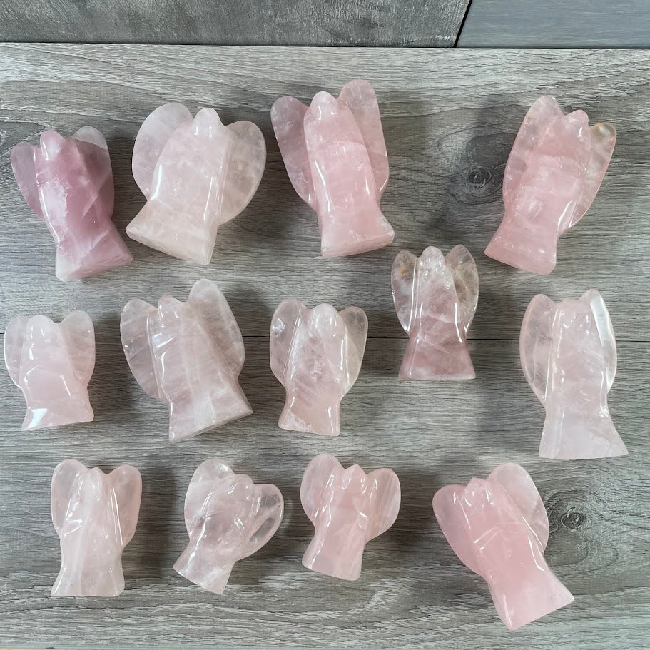 Lot of 13 stocky rose quartz angels, laying on back facing up. 