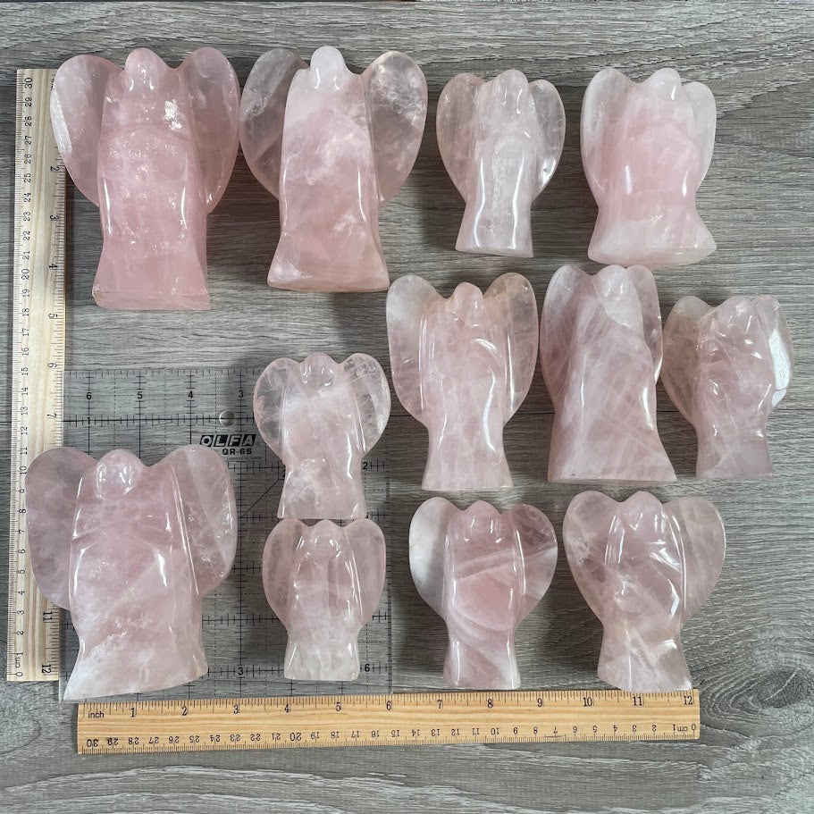 Lot of 12 stocky rose quartz angels, next to size reference. 