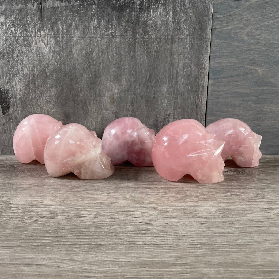 Lot of five rose quartz skulls, facing side. 