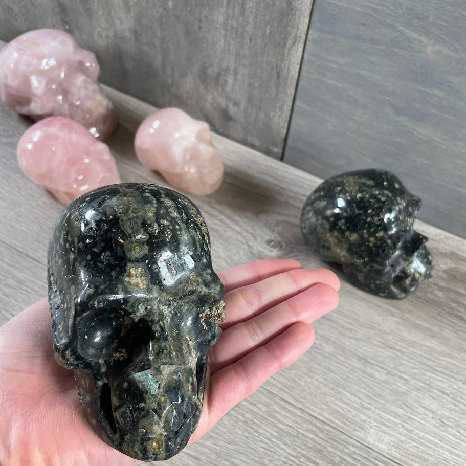 Close up of Kambaba Jasper skull with other skulls in the background. 