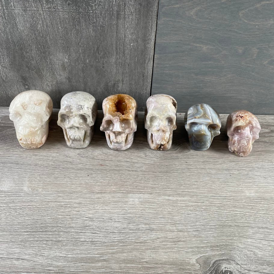 Lot of five quartz skulls and one agate skull; facing forwards. 