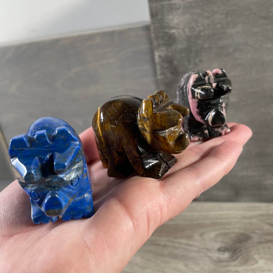Carved crystal dinosaur figurine shaped like a triceratops